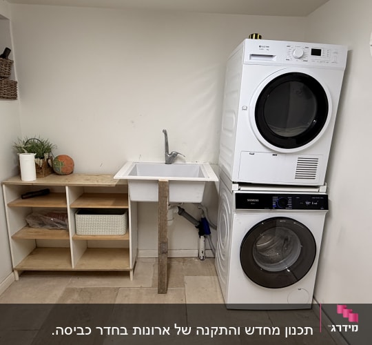 חדר כביסה עם מכונת כביסה ומייבש